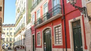 um edifício vermelho no lado de uma rua em Bairro Alto Suites em Lisboa
