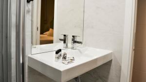 a bathroom with a white sink and a mirror at Bairro Alto Suites in Lisbon