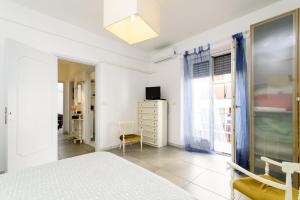 a white bedroom with a bed and a window at Casa Vacanze Nonna Elena in Rome