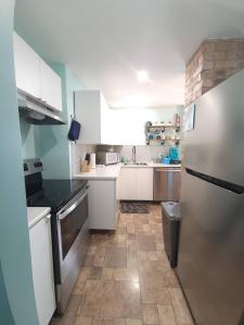 een keuken met witte kasten en een koelkast bij Quarto encantador in Nha Trang