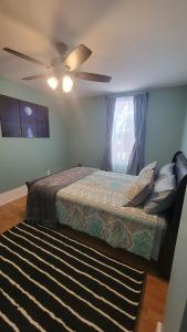 een slaapkamer met een bed en een plafondventilator bij Quarto encantador in Nha Trang