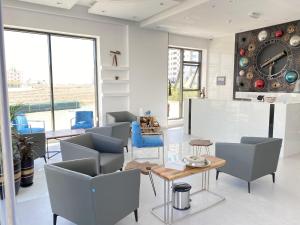 sala de estar con sillas y reloj en la pared en Al Falak Hotel فندق الفلك, en Ma‘ābīlah