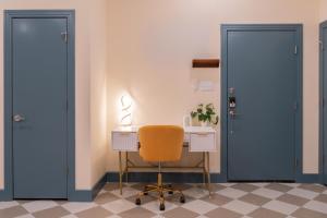 a desk with a yellow chair next to two doors at The Francesca - Apt 334 in Bryan