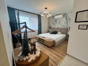 a bedroom with a bed and a christmas tree on a table at Malu Apartman in Sárvár