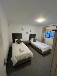 Plettenberg BaySunera Cottages的有两张床和一扇窗户的卧室