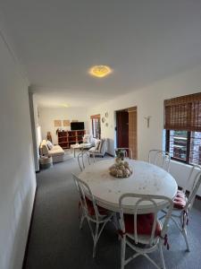 Plettenberg BaySunera Cottages的客厅里有一张白色的桌子和椅子