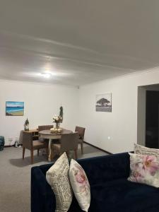 Plettenberg BaySunera Cottages的客厅里有一张蓝色的沙发和一张桌子 更多8张照片