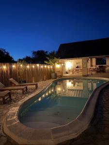 a swimming pool in a backyard at night at La Maison du Port Sauvage - Au bord de la Loire in Saint-Clément-des-Levées