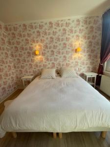 1 dormitorio con 1 cama blanca grande y papel pintado con motivos florales en Comfort with garden, en Fécamp