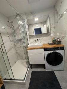 y baño con ducha, lavabo y lavadora. en Apartment Tatry in the center of Poprad with view, en Poprad 42 fotos más
