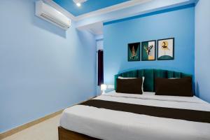 Un dormitorio azul con una cama y una pared azul. en Hotel O kumar inn, en Lok Nayak Jayaprakash Airport