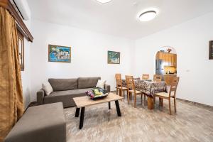 a living room with a couch and a table and chairs at Serenity House - Magic sunsets in Asfendioú
