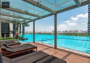 a large swimming pool with a view of a city at The Metropole Golden Horizon Residence in Ho Chi Minh City