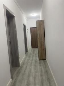 pasillo vacío con puertas de madera en una habitación en Two modern apartments, en Sibiu