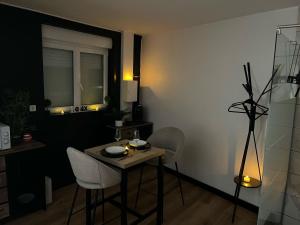 a dining room with a table and chairs and a window at CY L'unique instant in Wingles