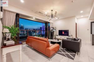 a living room with a couch and a tv at The Metropole Golden Horizon Residence in Ho Chi Minh City