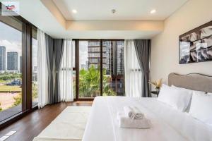 a bedroom with a large white bed and a large window at The Metropole Golden Horizon Residence in Ho Chi Minh City +244 photos