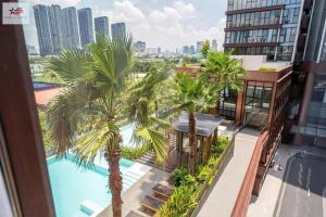 a view from the balcony of a building with palm trees at The Metropole Golden Horizon Residence in Ho Chi Minh City