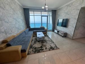 a living room with a couch and a tv at Sunrise Ajman sea view in Ajman 
