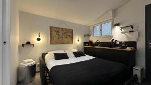 a bedroom with a large bed and a sink at Le mini loft - Centre-ville in Nevers