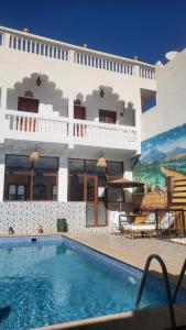 a large house with a swimming pool in front of it at Dar Ilyana in Aït Tiourhza
