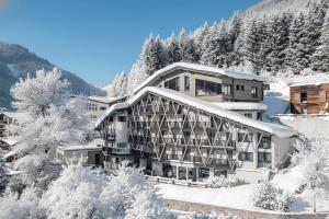 a hotel in the snow with a mountain at ARPURIA l 4 Star Superior l Adults Only in Sankt Anton am Arlberg