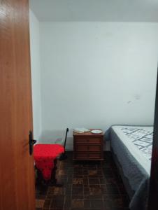 马林加Casa doce Lar的一间卧室配有床、梳妆台和红色凳子