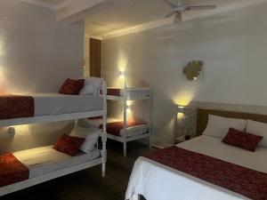 een kamer met 2 stapelbedden en een plafondventilator bij Recanto Guaraú 4 in Peruíbe