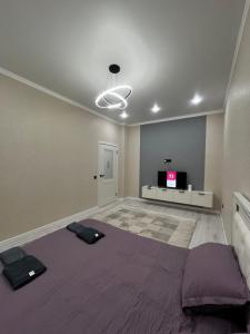 Квартира في Taldykolʼ: غرفه فيها سرير وتلفزيون +صورتان