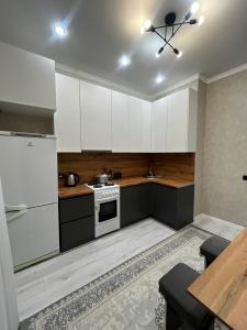 Квартира في Taldykolʼ: مطبخ بخزائن بيضاء وفرن موقد