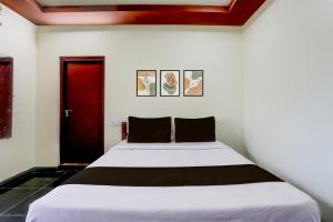 a bed in a room with a red door at Collection O Chirala Beach View Formerly Sea Shell Resort in Vadarevu