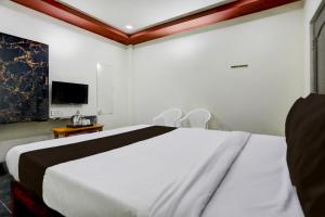 a bedroom with a large white bed and a tv at Collection O Chirala Beach View Formerly Sea Shell Resort in Vadarevu
