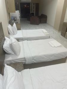 two beds in a room with white sheets and pillows at vision suites Arbia Hurghada in Hurghada