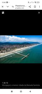 a picture of a plane flying over a beach at Casa top com piscina em Mongaguá in Mongaguá