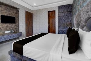 Un dormitorio con una cama y un televisor en una pared. en Hotel O RG PALACE HOTEL, en Bagru
