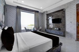 Un dormitorio con una cama grande y un televisor. en Hotel O RG PALACE HOTEL, en Bagru