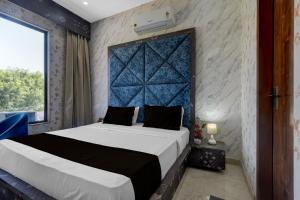 Un dormitorio con una cama grande con cabecero azul. en Hotel O RG PALACE HOTEL, en Bagru