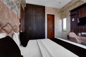 Un dormitorio con una cama grande y un escritorio. en Hotel O RG PALACE HOTEL, en Bagru