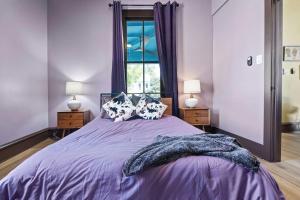 a bedroom with a purple bed with two lamps and a window at Historic French Royal Estate at Capitol, Downtown! in Austin