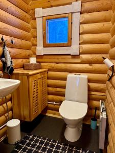 ein Badezimmer mit Toilette in einer Blockhütte in der Unterkunft Kantolammen mökki 66m2, kylpypalju ja puusauna in Kuusamo
