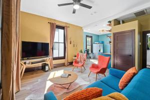 a living room with a blue couch and red chairs at Historic French Royal Estate at Capitol, Downtown! in Austin