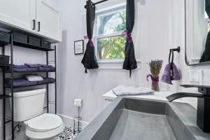 a bathroom with a tub and a toilet and a window at Historic French Royal Estate at Capitol, Downtown! in Austin +25 photos