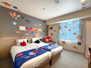a bedroom with two beds with fish on the wall at Henn na Hotel Tokyo Nishikasai in Tokyo