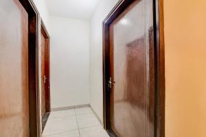 un couloir avec une porte en bois et un sol carrelé dans l'établissement Hotel O Fresh Stay Hotel, à Patiala
