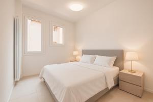 博洛尼亚Malvasia Asinelli Tower View - Residenza Oberdan, Bologna Centre的一间白色卧室,配有床和2个窗户