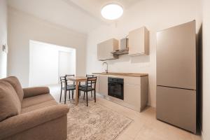 博洛尼亚Malvasia Asinelli Tower View - Residenza Oberdan, Bologna Centre的客厅设有厨房和桌椅