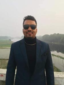 un hombre de traje y gafas de sol está de pie en Suite property insurance groups of company, en Dhaka