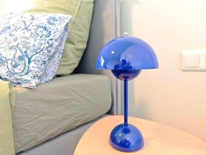a blue lamp sitting on a table next to a couch at Your home with iconic TV tower views in Stuttgart