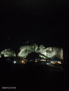 eine Gruppe großer Felsen bei Nacht mit Lichtern in der Unterkunft Zara'sHomeMeteora-The House Of The Rising Sun! in Kalambaka