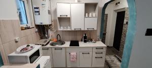 a small kitchen with a sink and a microwave at VITAN Central Apartament in Tîrnăveni +1 photo